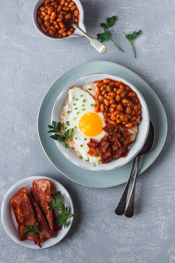 savory oatmeal topped with baked beans, egg and bacon