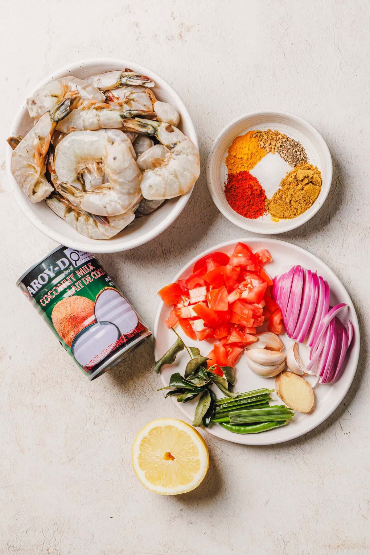 ingredients for sri lankan prawn curry on a cream background.