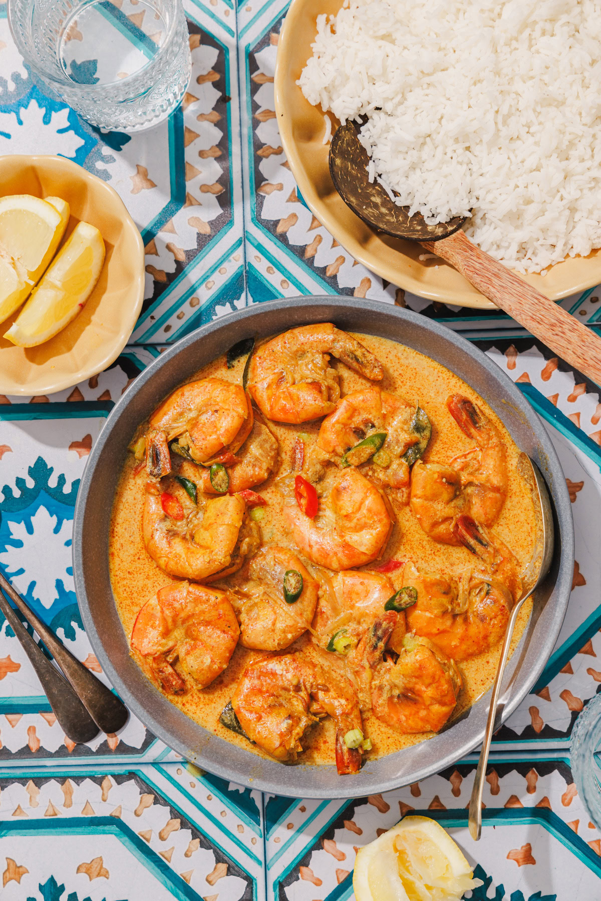 sri lankan prawn curry in a blue bowl with rice on the side.