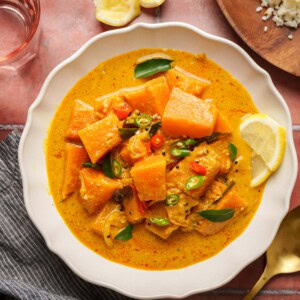 sri lankan pumpkin curry in a bowl on a brown surface.