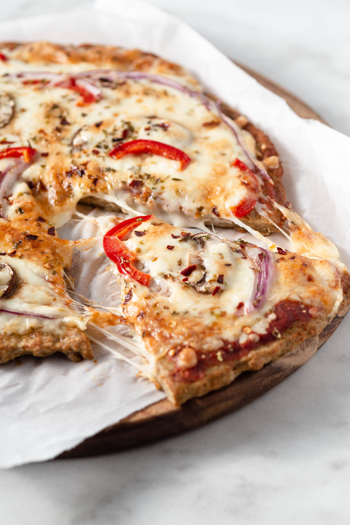 keto chicken crust pizza slice pulled with cheese oozing