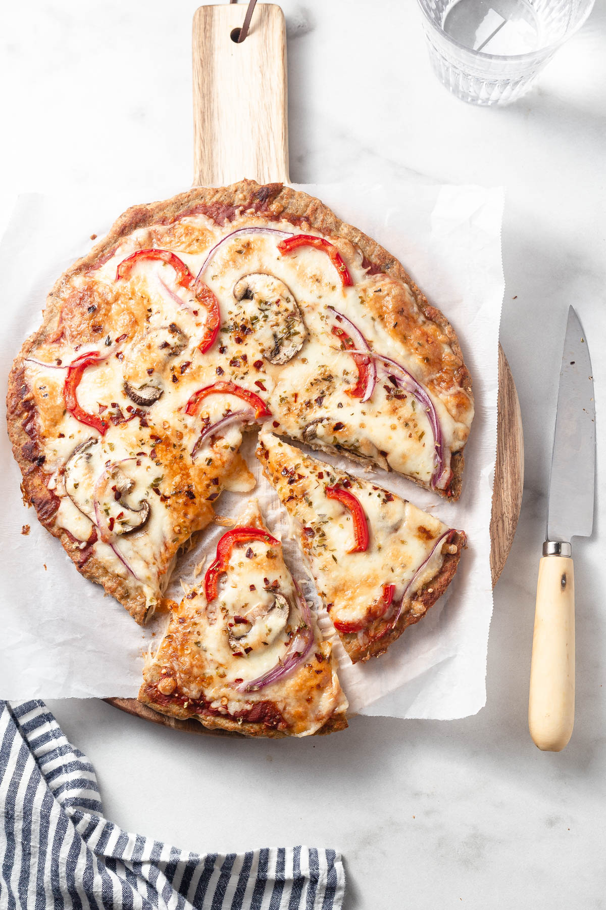 keto chicken crust pizza cut with a knife next to it
