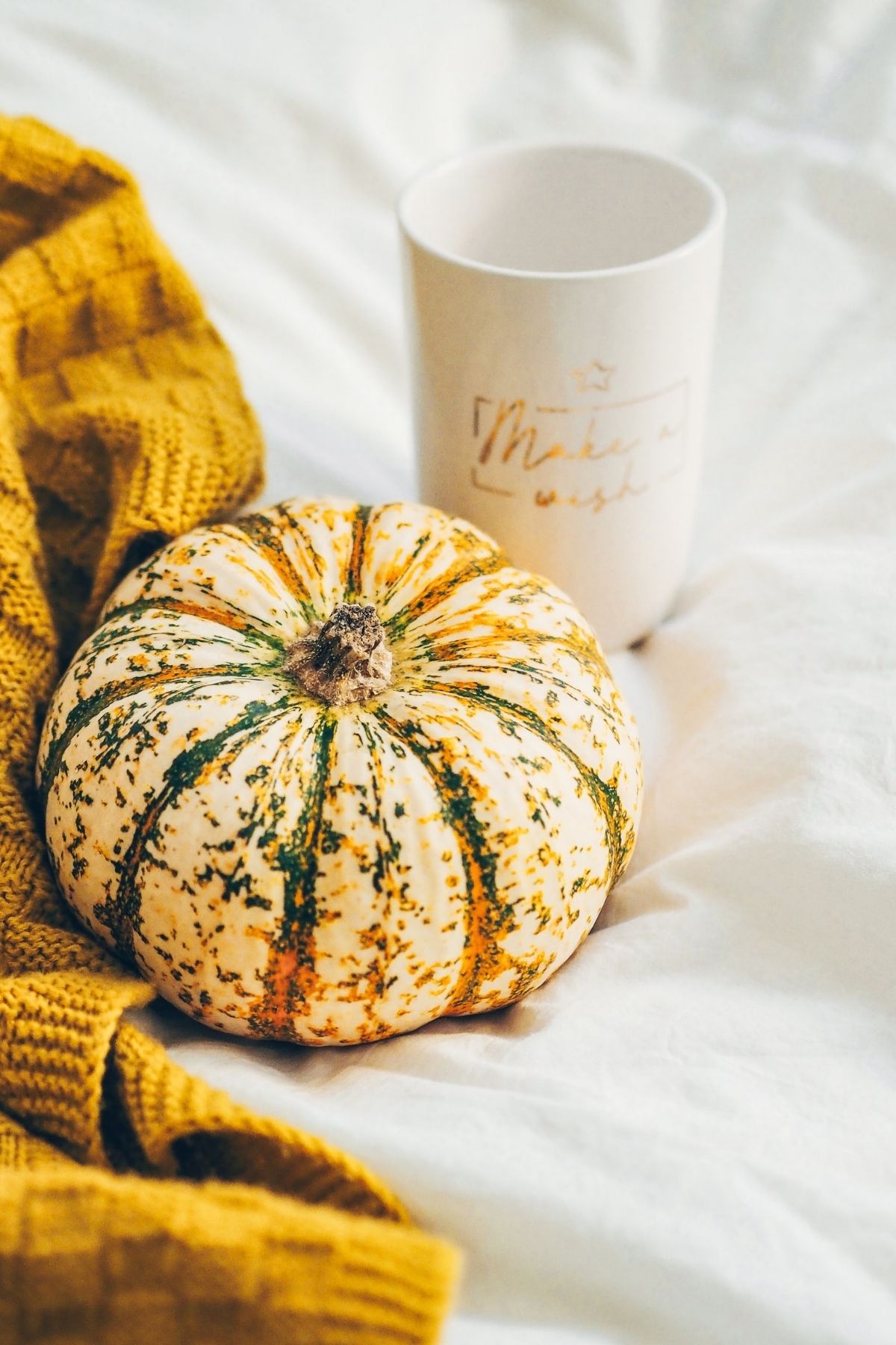 pumpkin with a cup and sweater in the background
