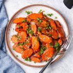 air fryer carrots on a plate with parsley and sesame seeds