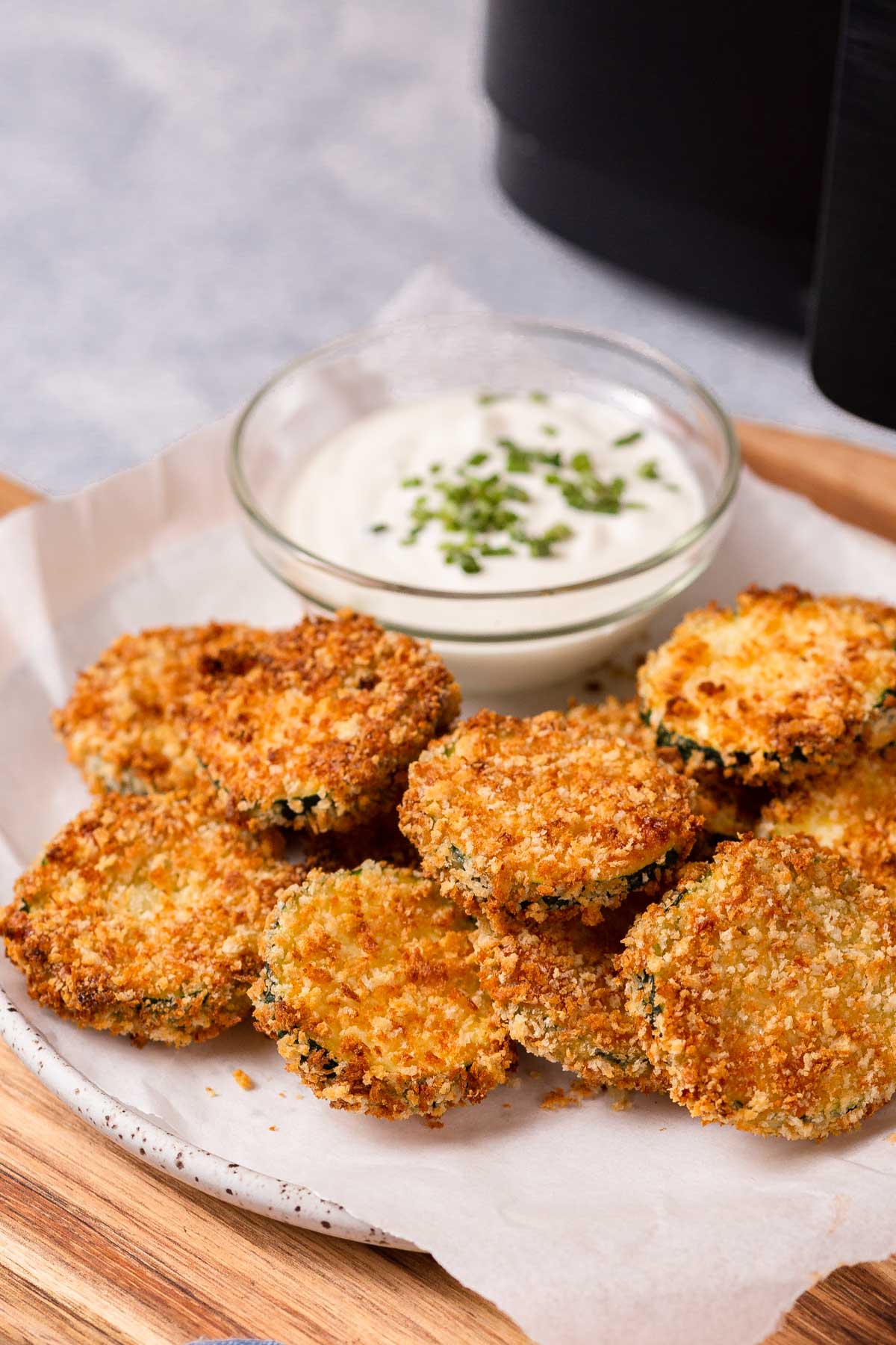 air fryer zucchini chips on a plate with dip