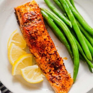 air fried salmon with green beans and lemon wedges.
