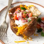 air fryer baked potatoes with cheddar, sour cream and onions.