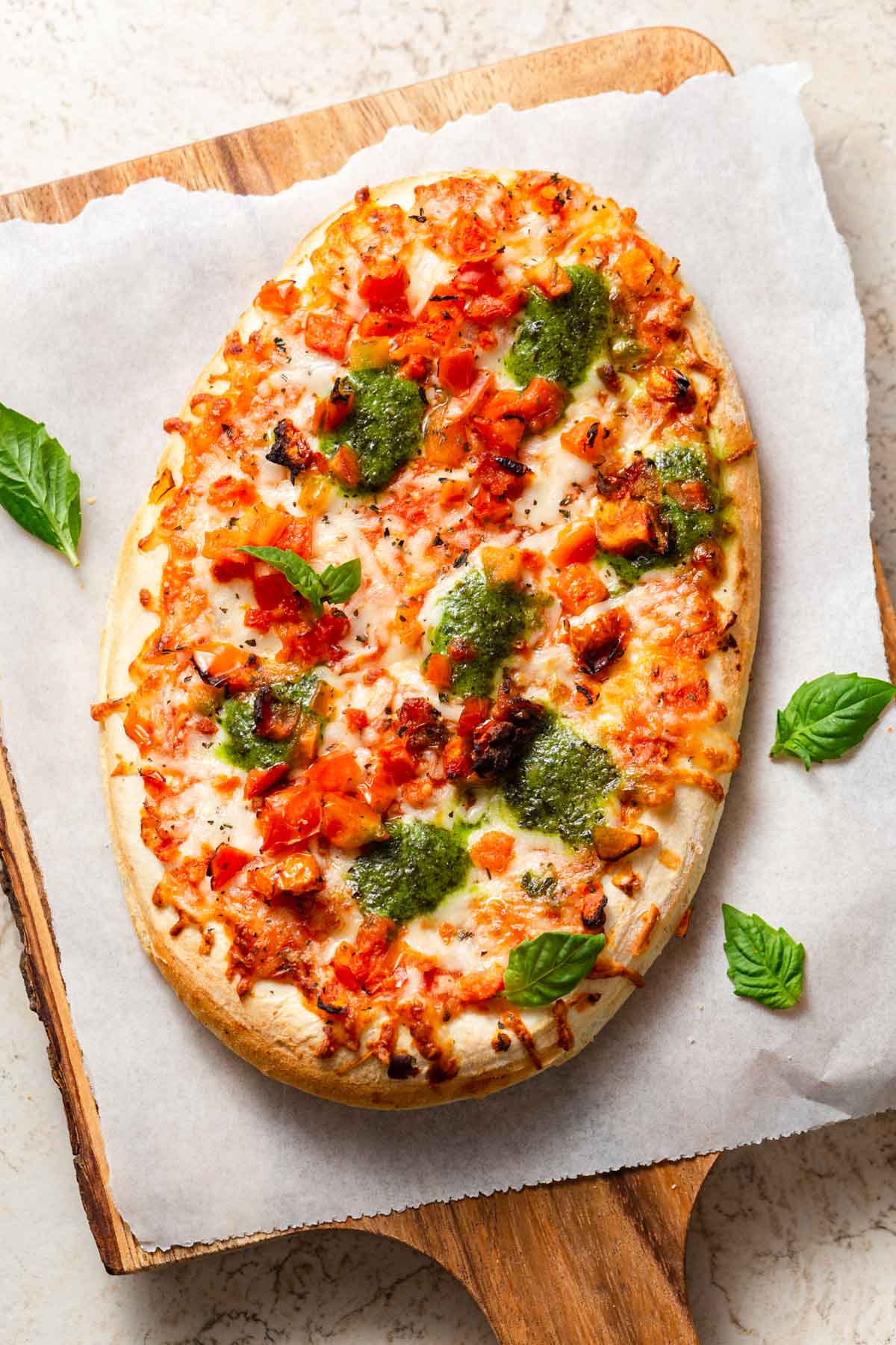 air fried frozen pizza with basil leaves on a chopping board