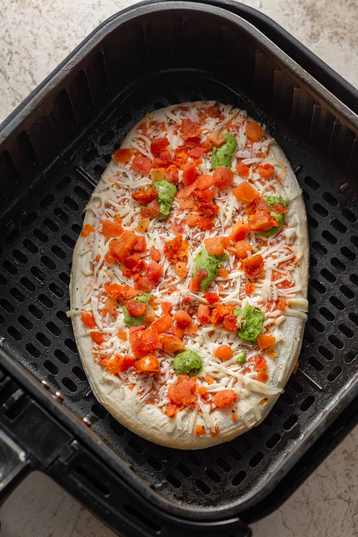 frozen pizza in the air fryer basket.