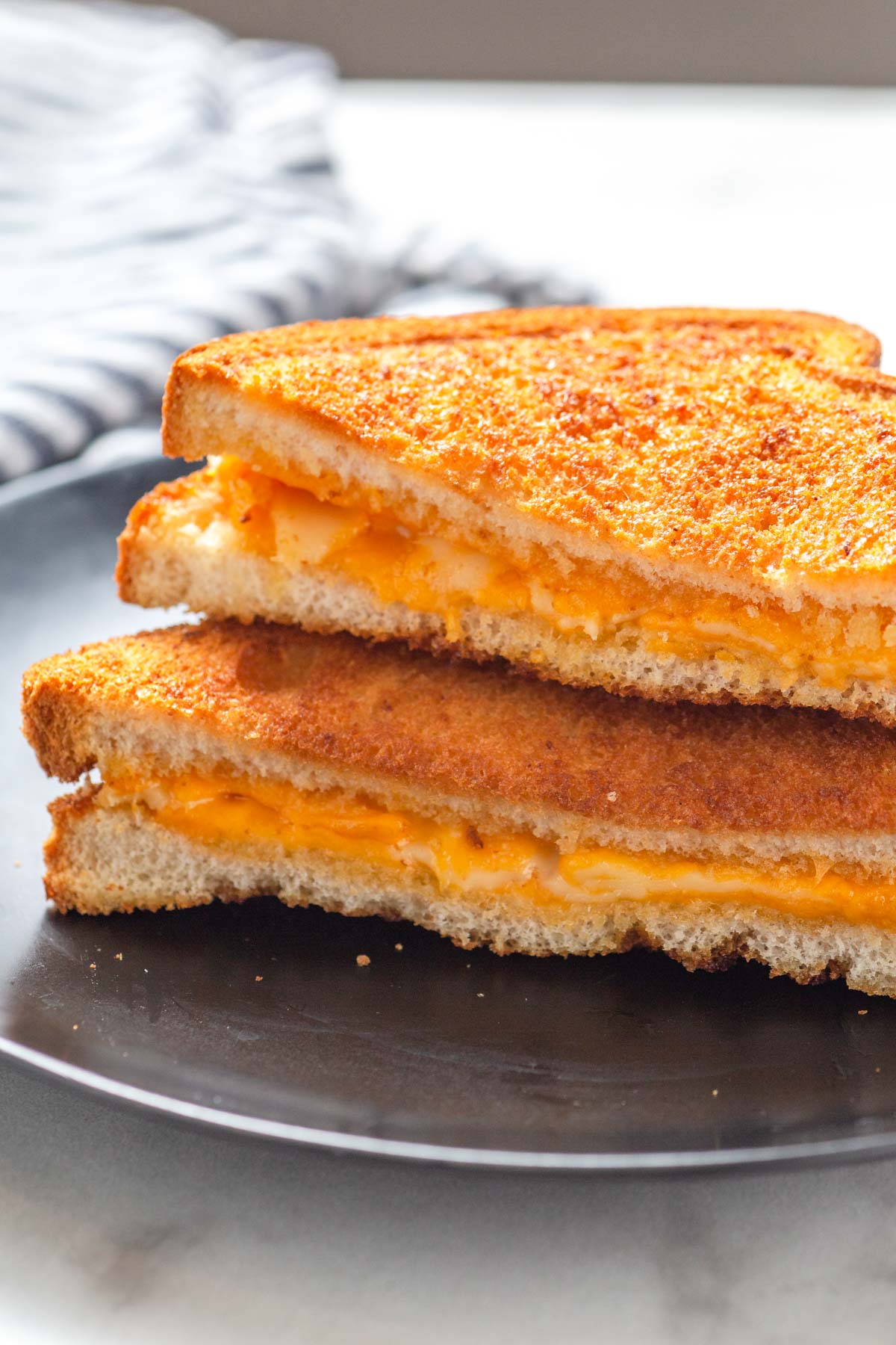 air fryer grilled cheese cut in half and in a plate