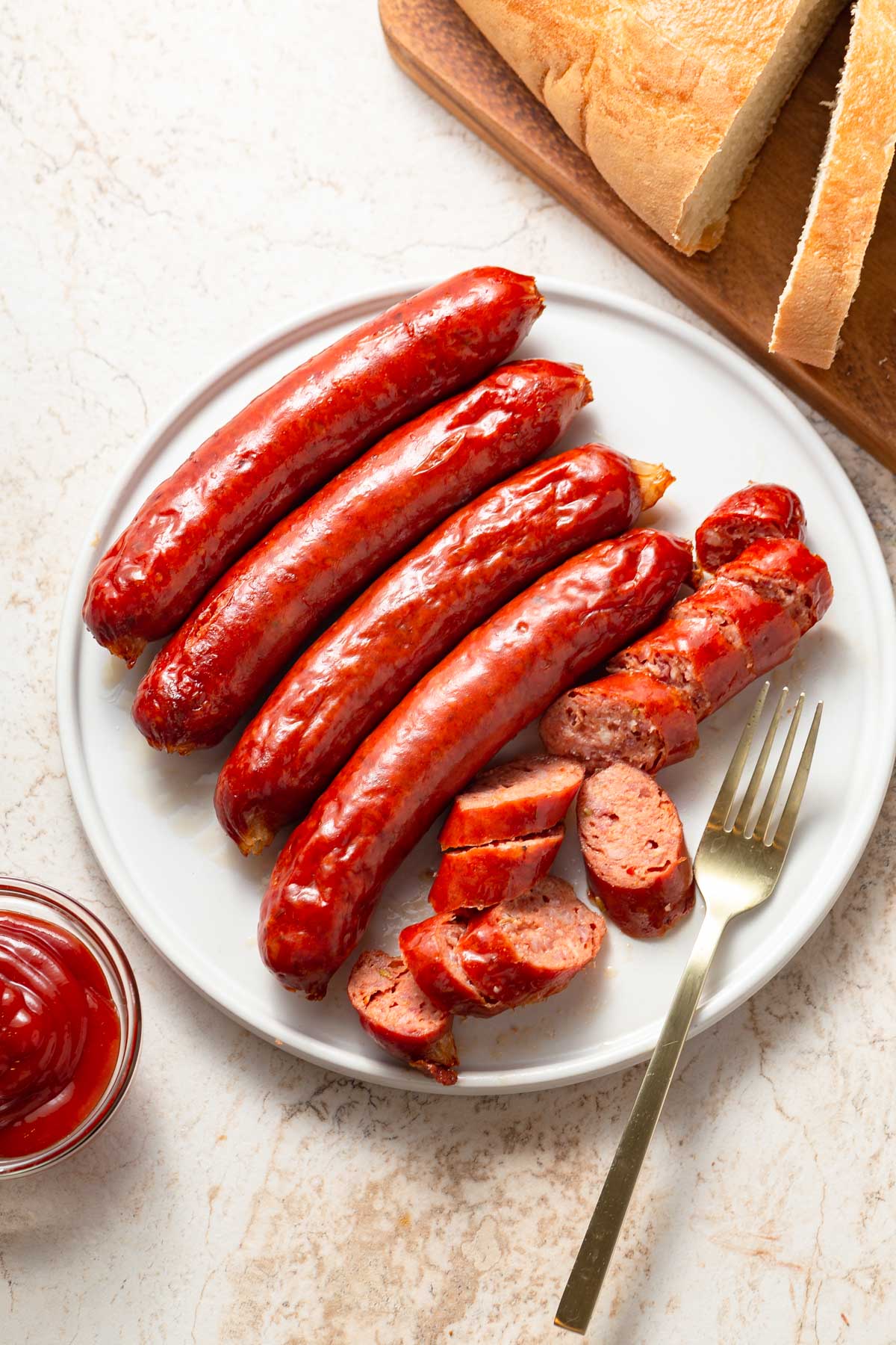 air frued sausages on a place with one cut up and a fork by the side.