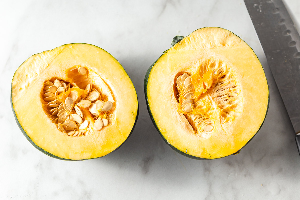 acorn squash cut open with a knife