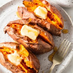 3 baked sweet potatoes in the air fryer with butter and maple syrup.