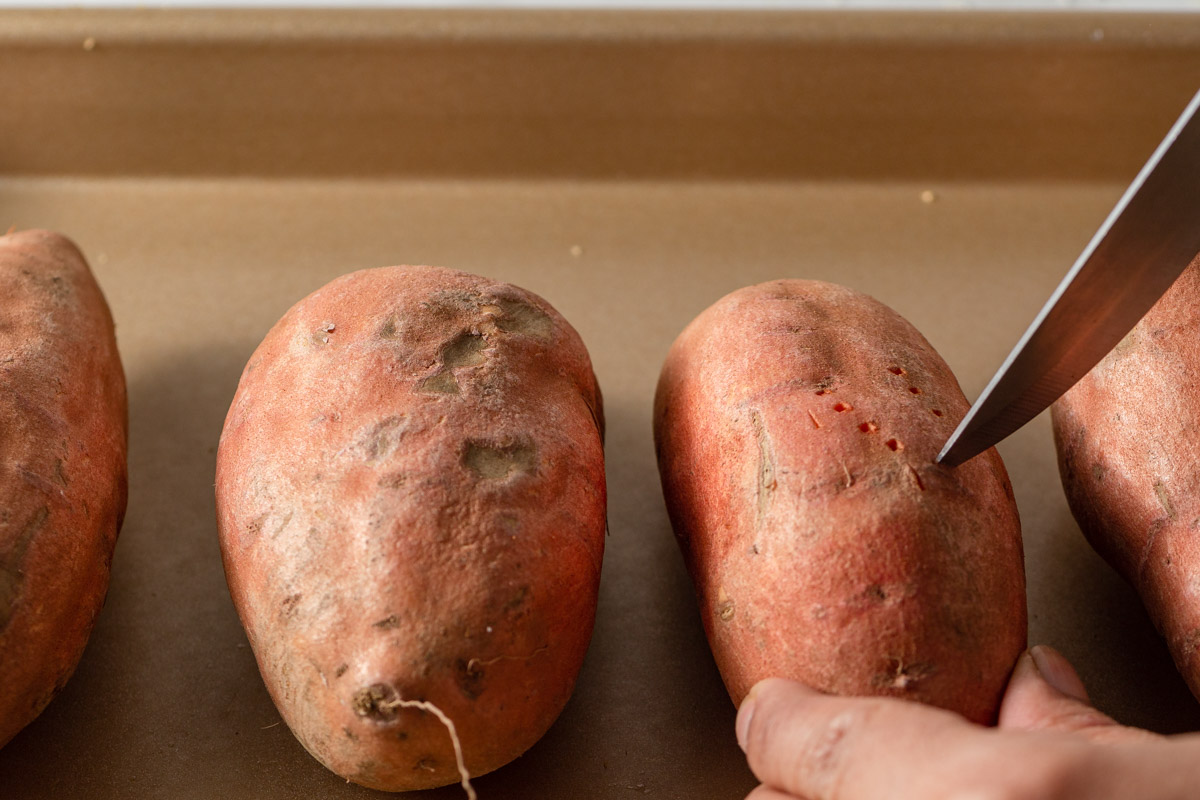 poking the sweet potato with a knife.