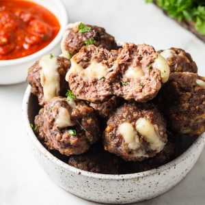 air fryer cheese stuffed meatballs with marinara sauce on the side.