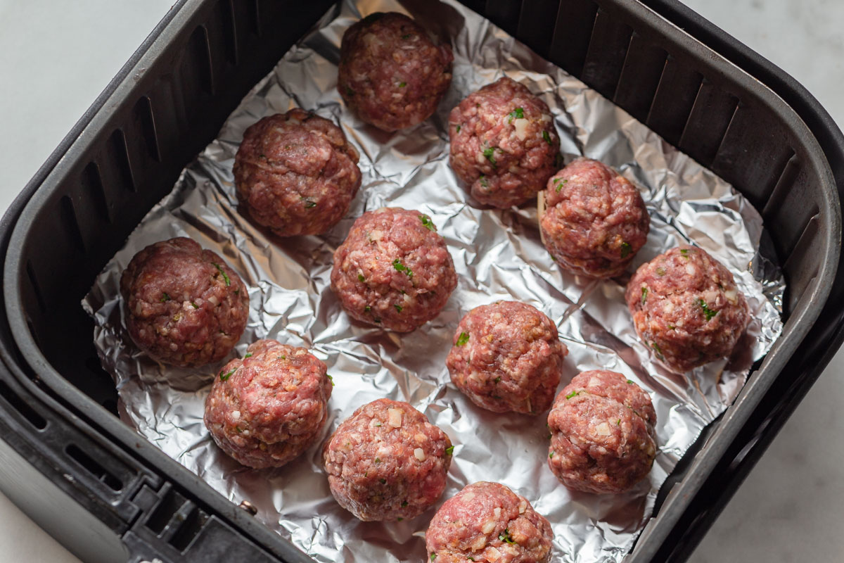 cheese stuffed meatballs in the air fryer basket.