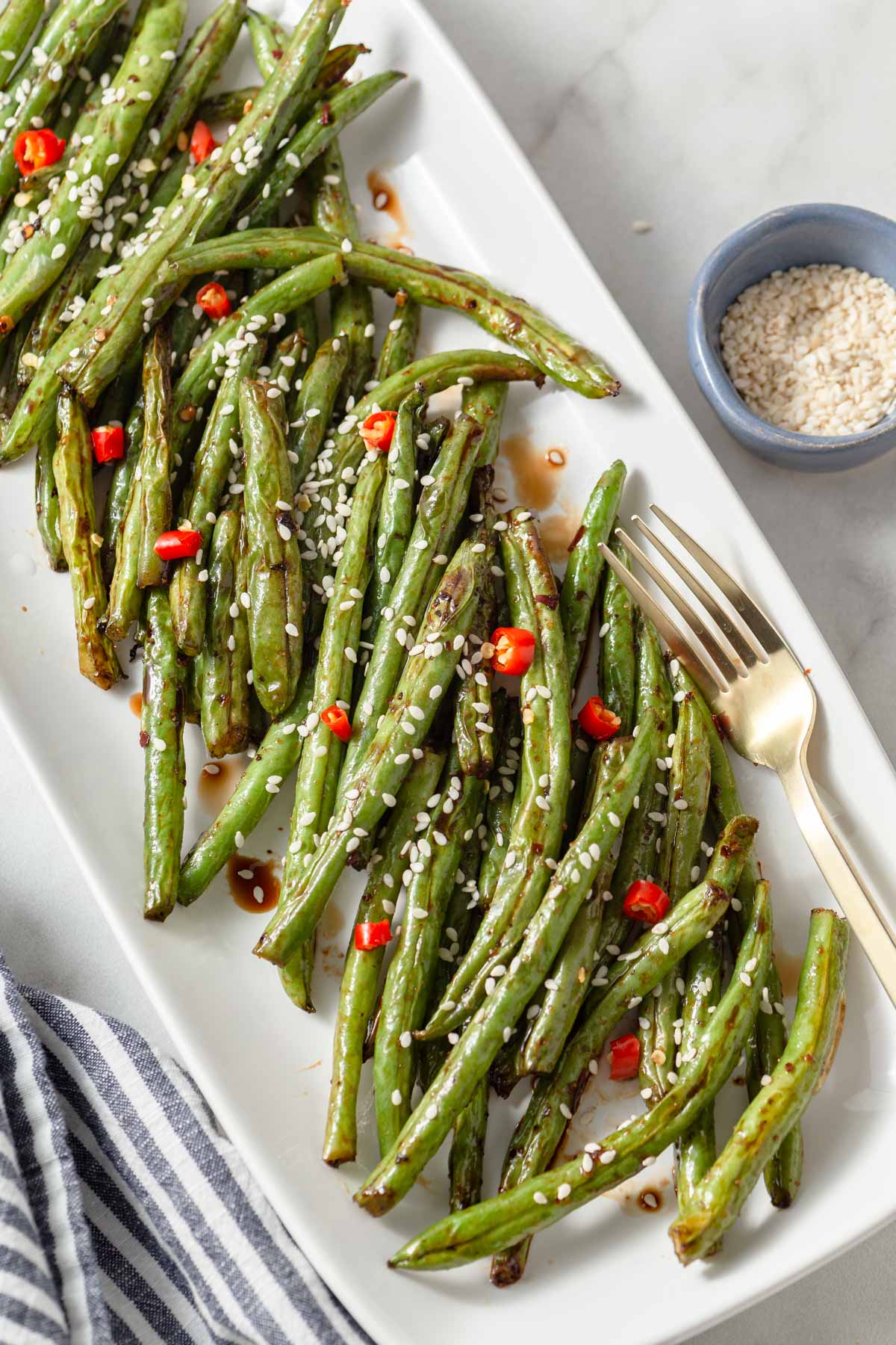 air fryer asian green beans on a plate with a fork.