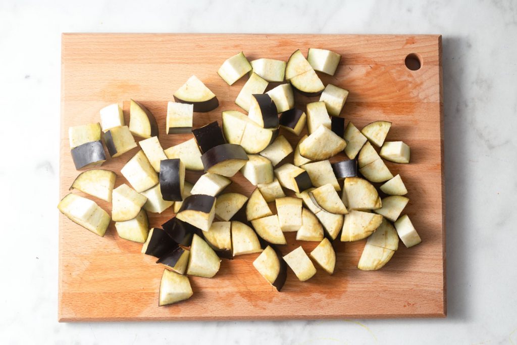cutting eggplant cubes from the slices.