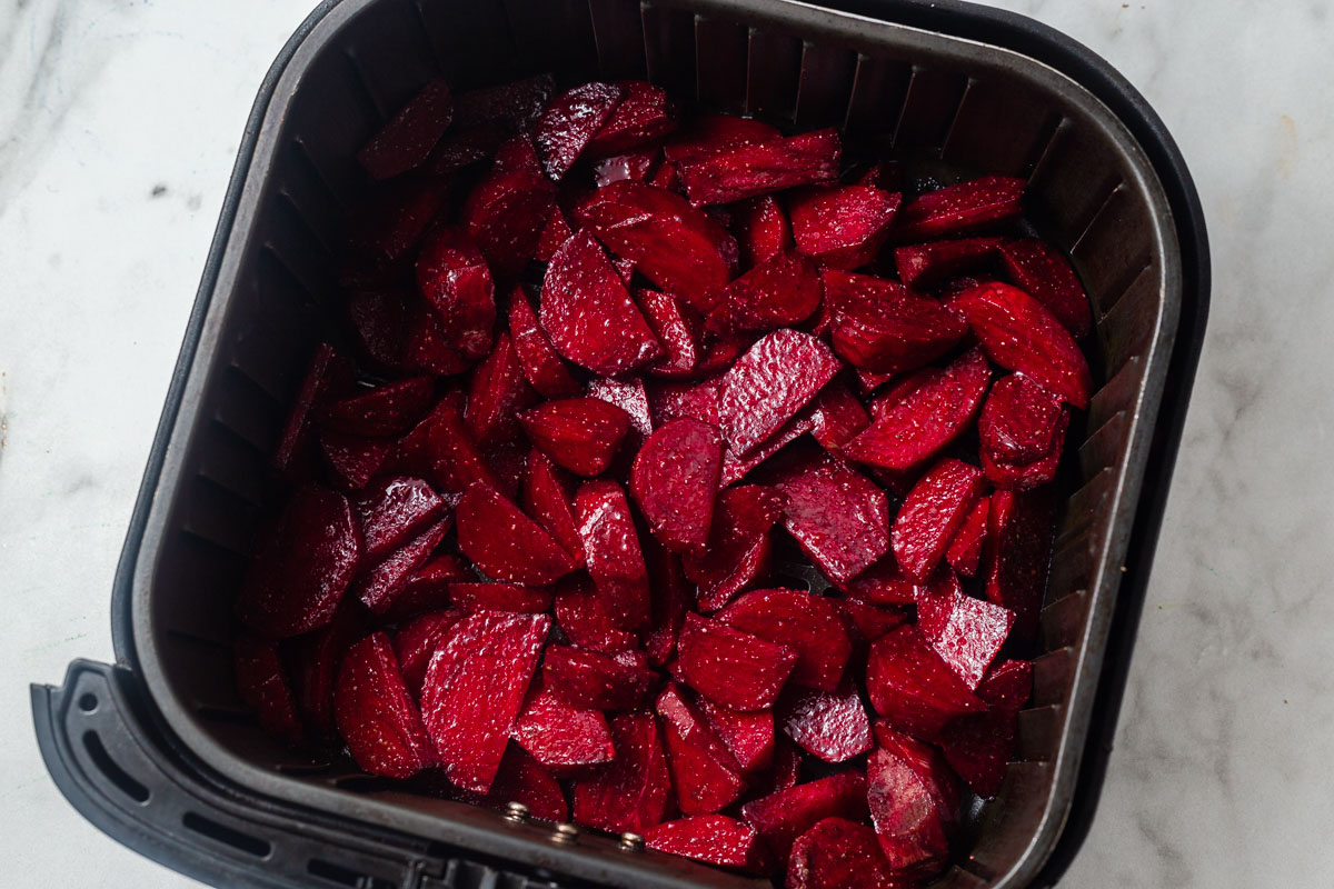 sliced and seasoned beets in the air fryer.