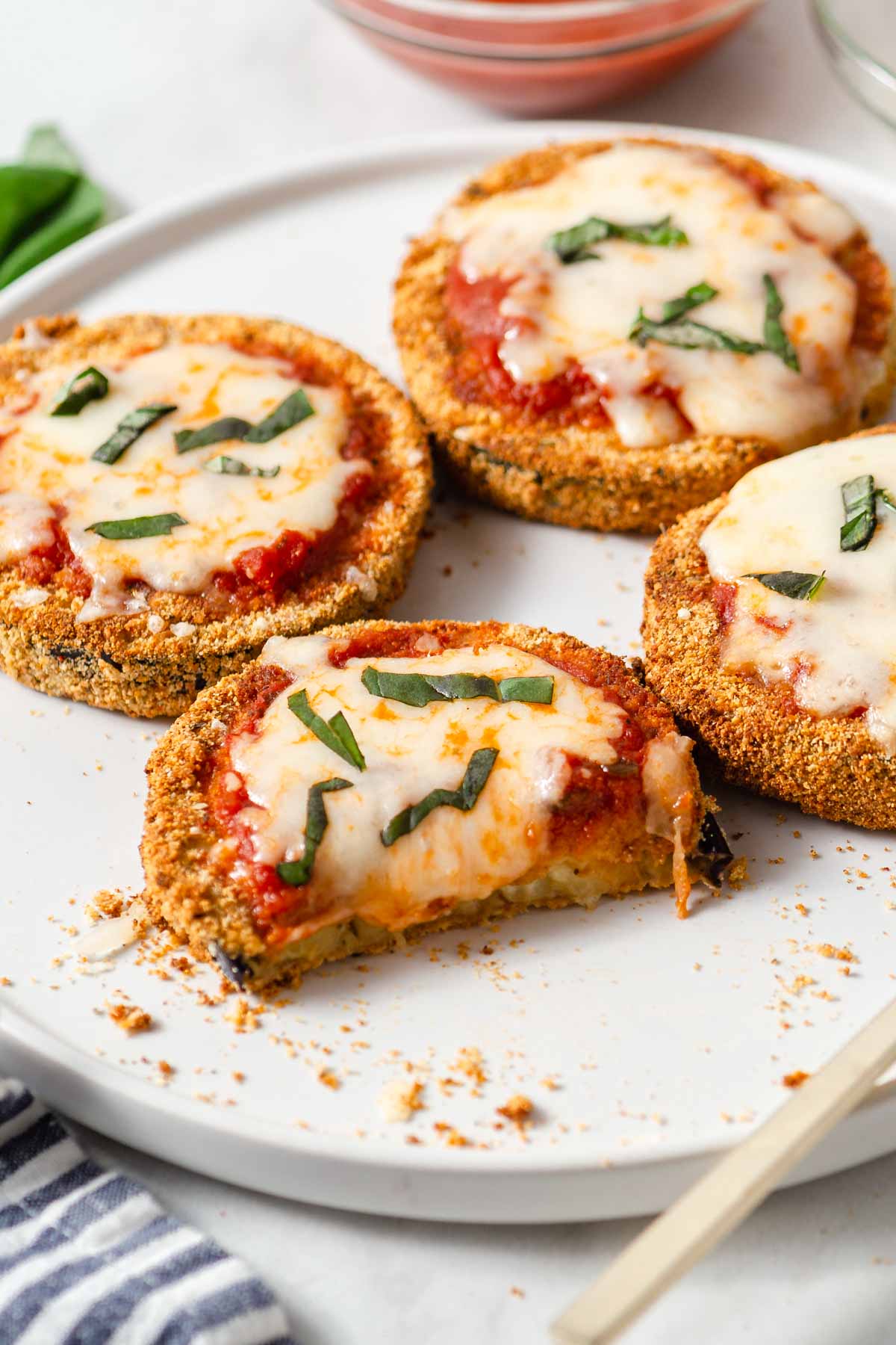 air fried eggplant parmesan on a plate with cheese oozing out.