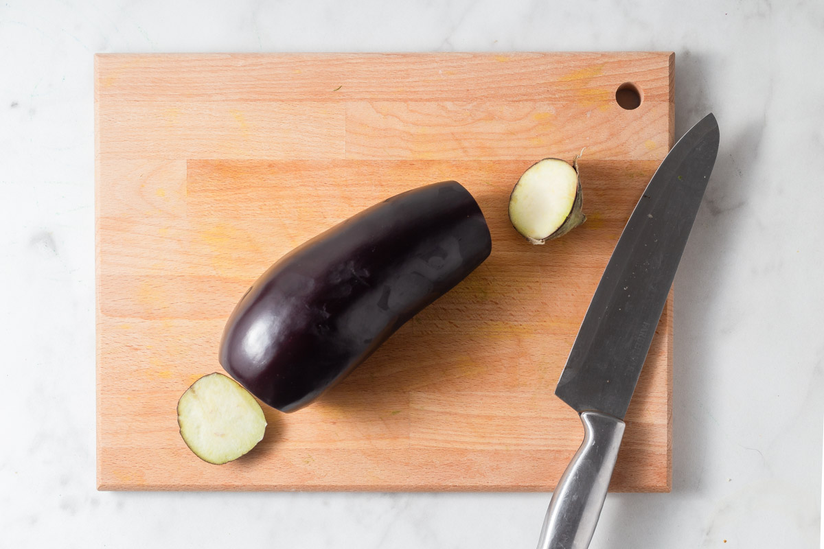 cutting the ends off of eggplant.