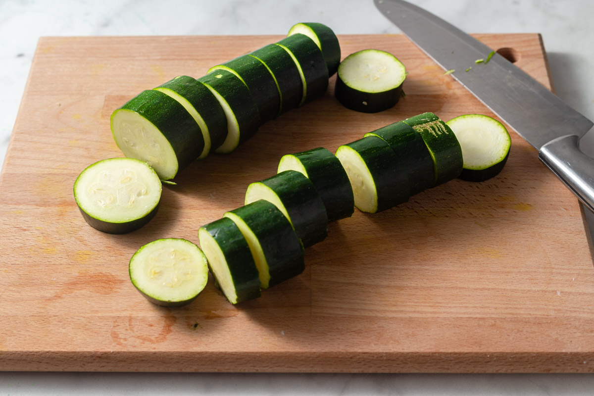 cutting the zucchini into slices.