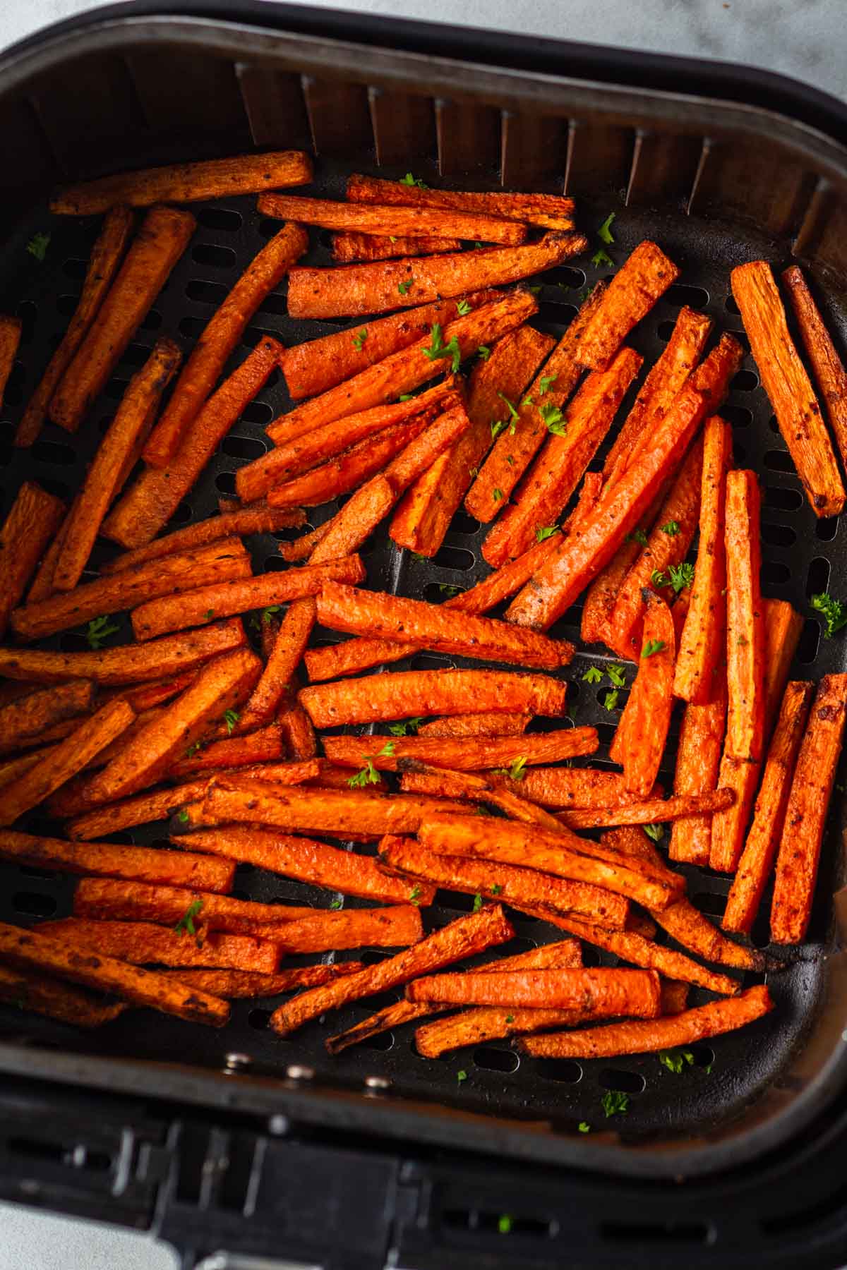 air fried carrot fries in the air fryer basket.