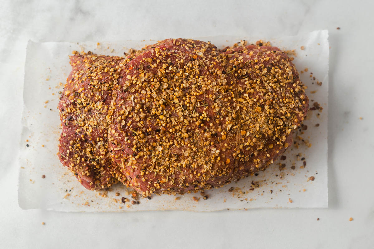 coating the roast beef with spices.