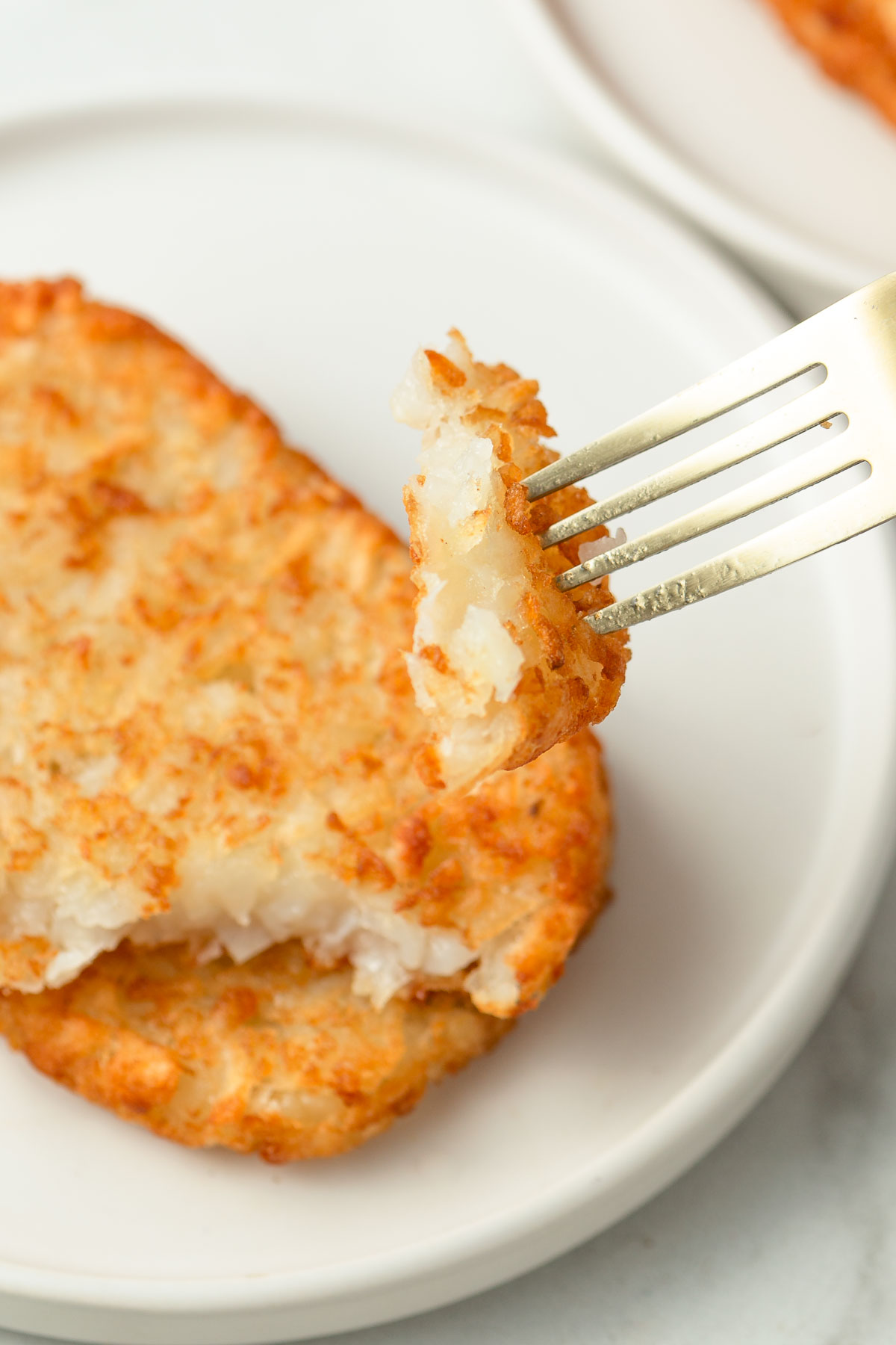 crispy air fryer hash browns with a piece on fork.