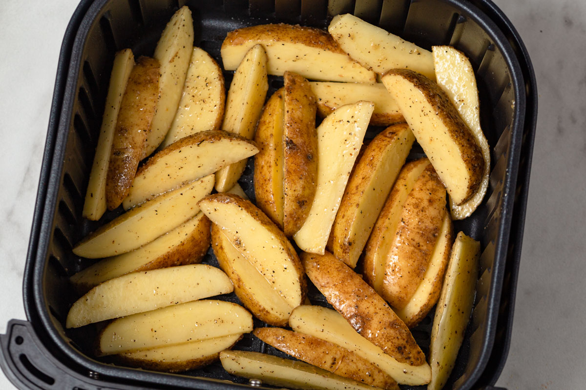 potato wedges in the air fryer basket.