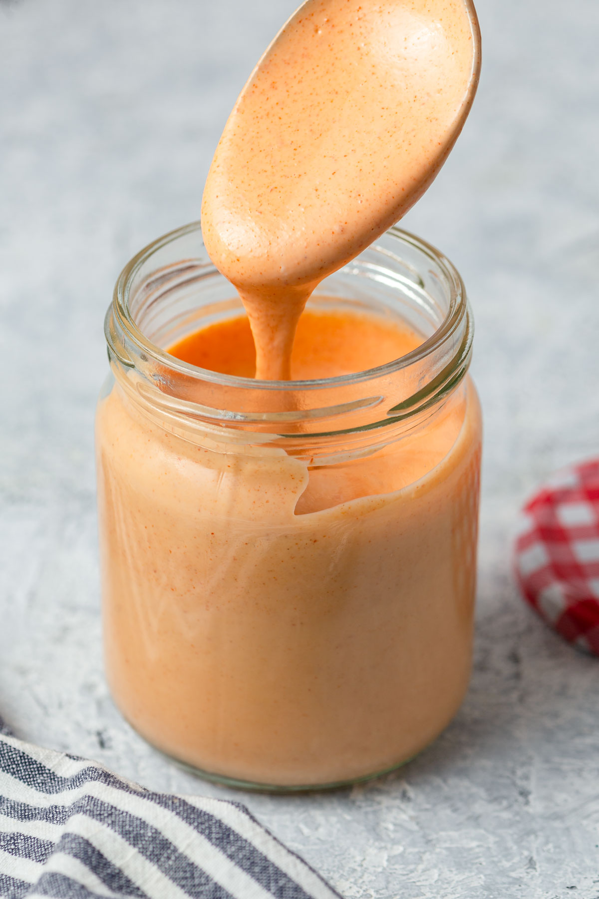 spicy mayo sauce recipe in a jar with a spoon.