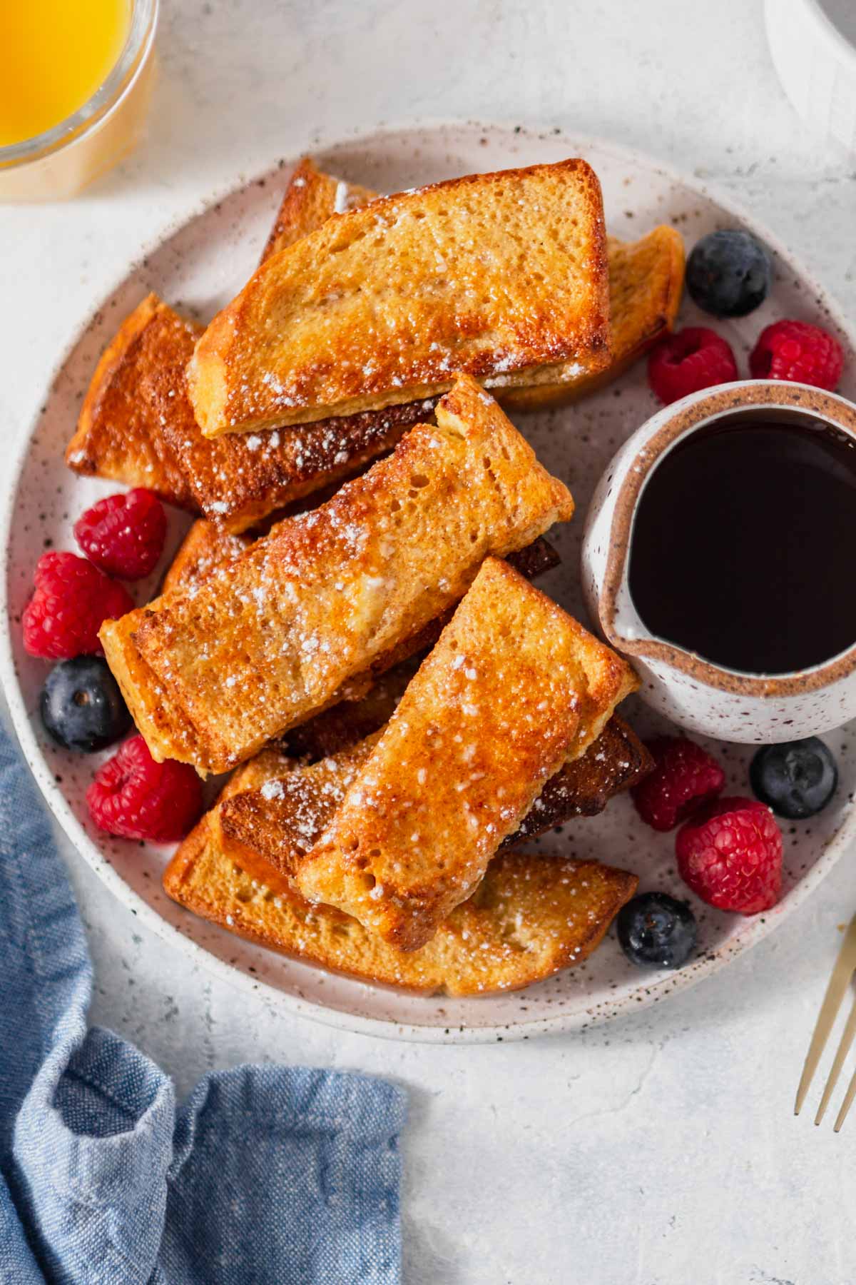 air fryer French toast sticks on a plate with syrup.