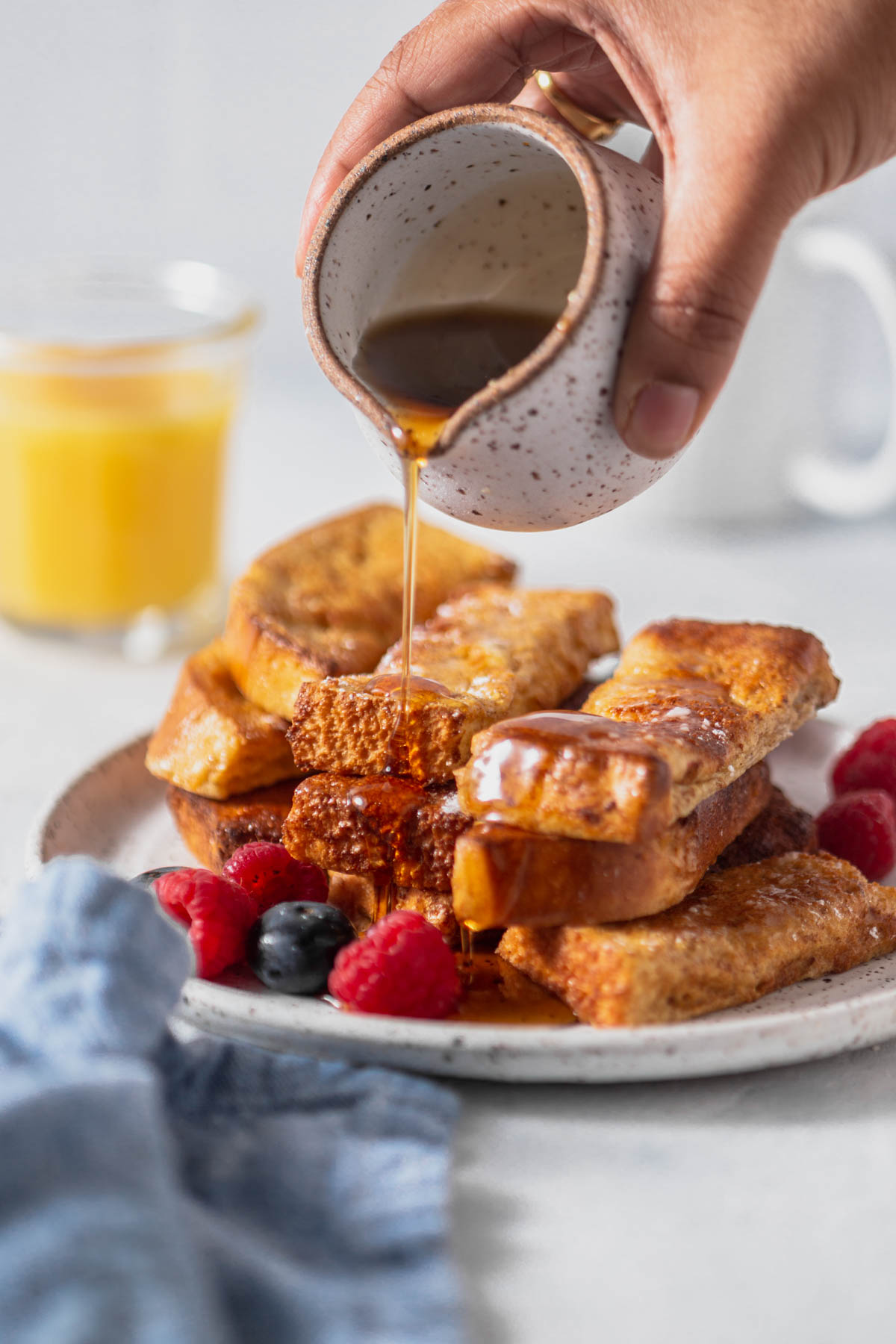 Maple syrup is poured over air fryer French toast sticks.