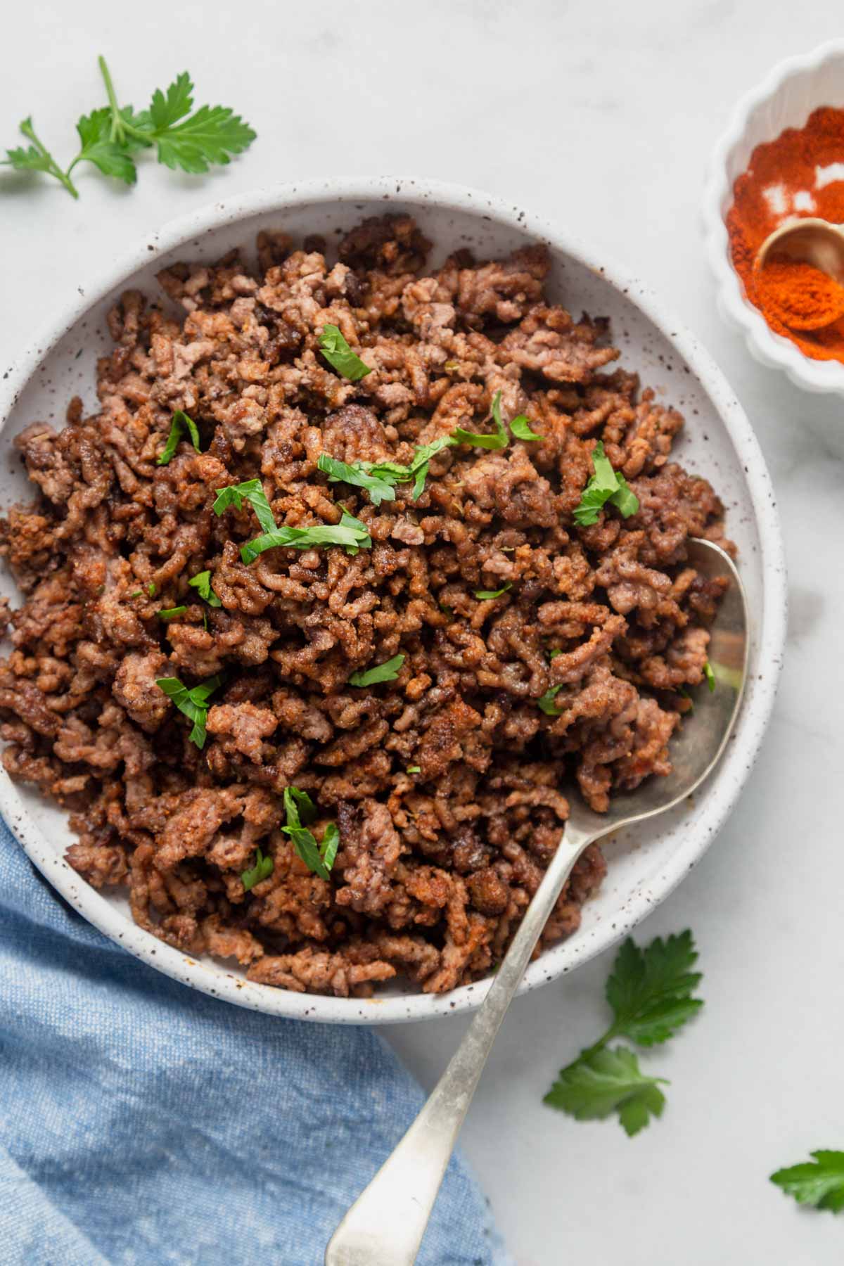 air fryer ground beef or taco meat on a plate with parsley.