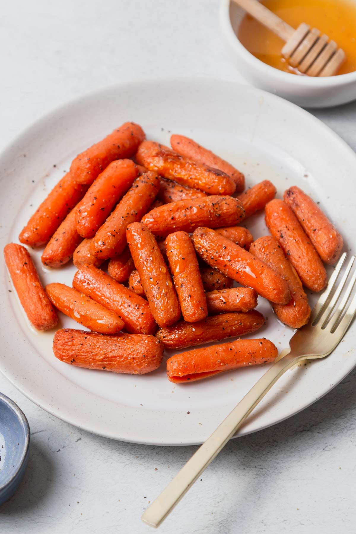 air fryer baby carrots on a plate with a fork.