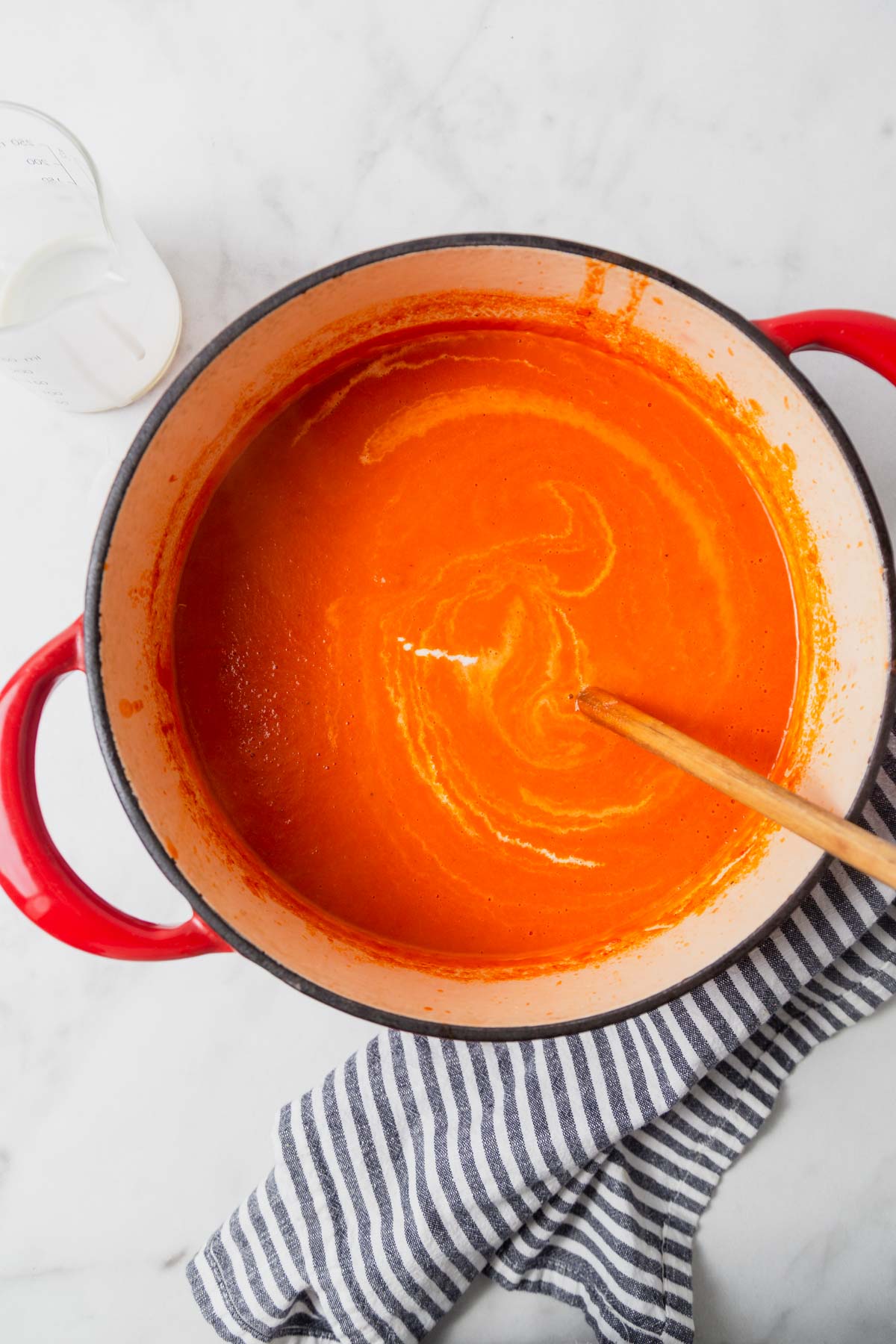 adding cream to the tomato soup.