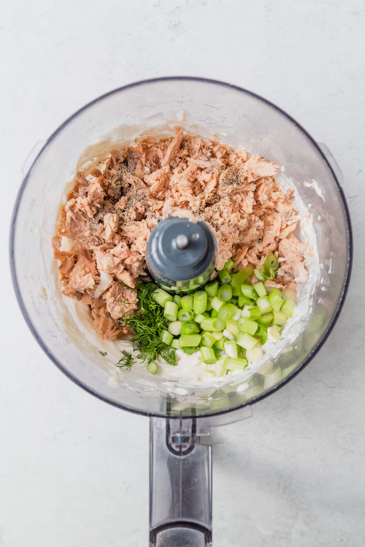 adding the canned salmon to the cream cheese in the food processor.
