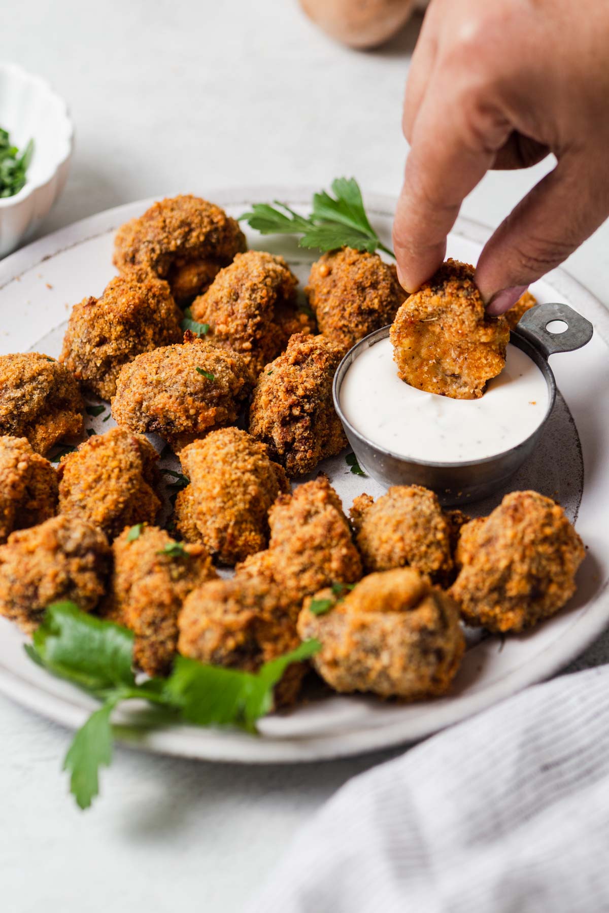 crispy air fryer breaded mushrooms with a ranch dip on the side.