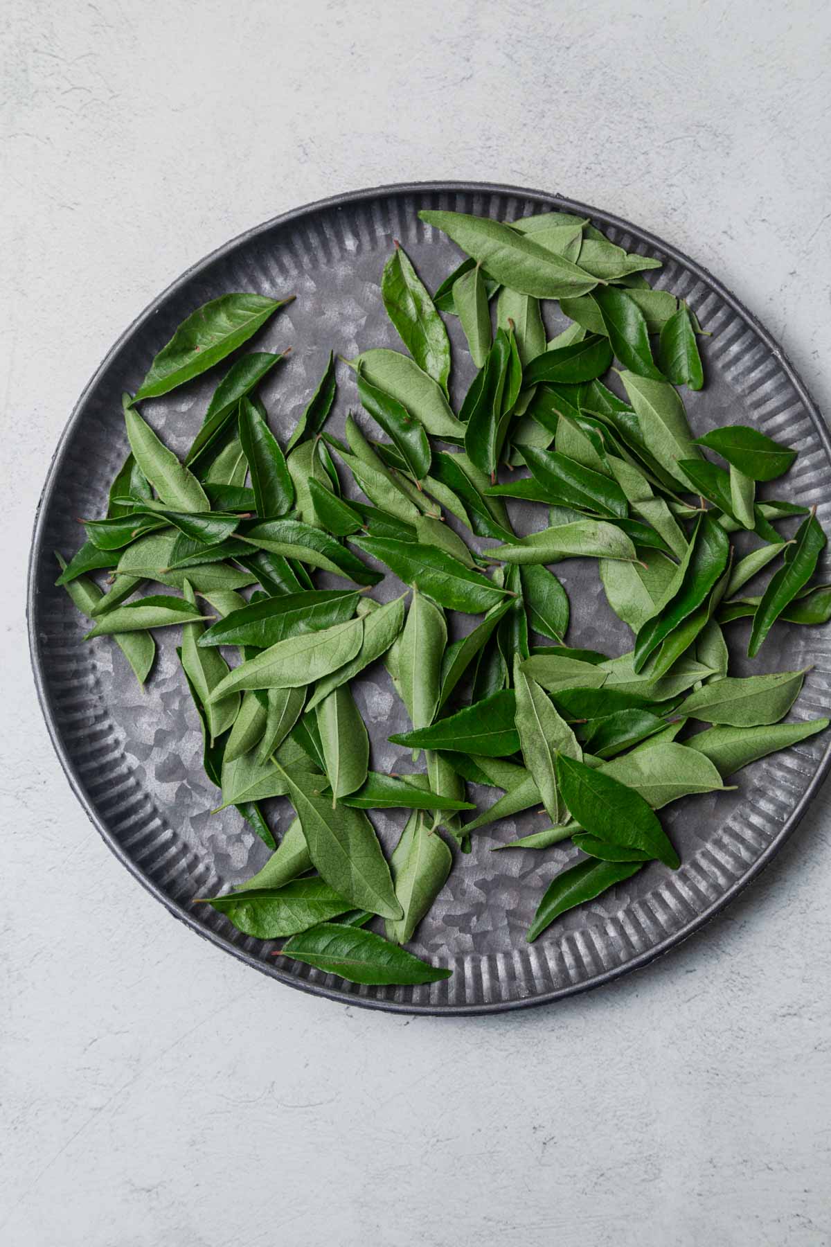curry leaves on a large tray.