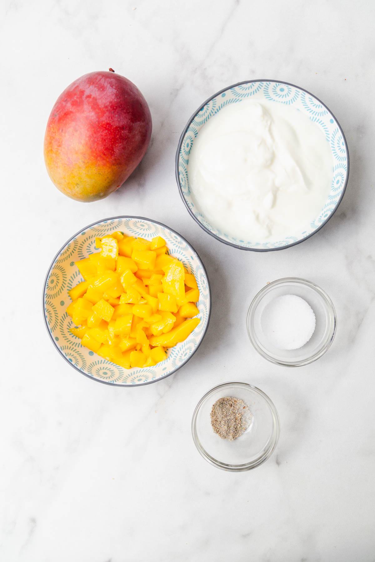 ingredients for mango lassi on a white background.