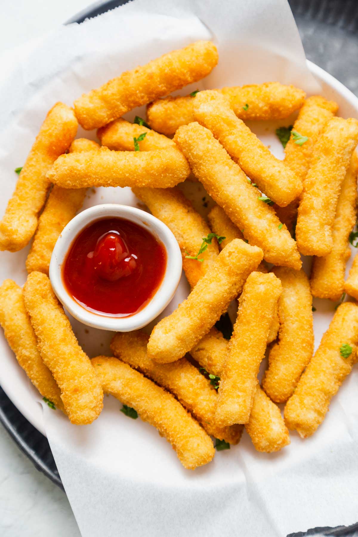 air fryer frozen chicken fries in a plate with ketchup.