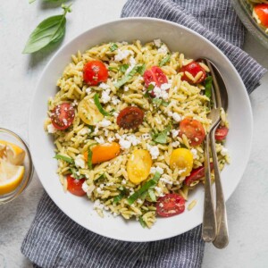 pesto orzo salad on a bowl with a spoon.