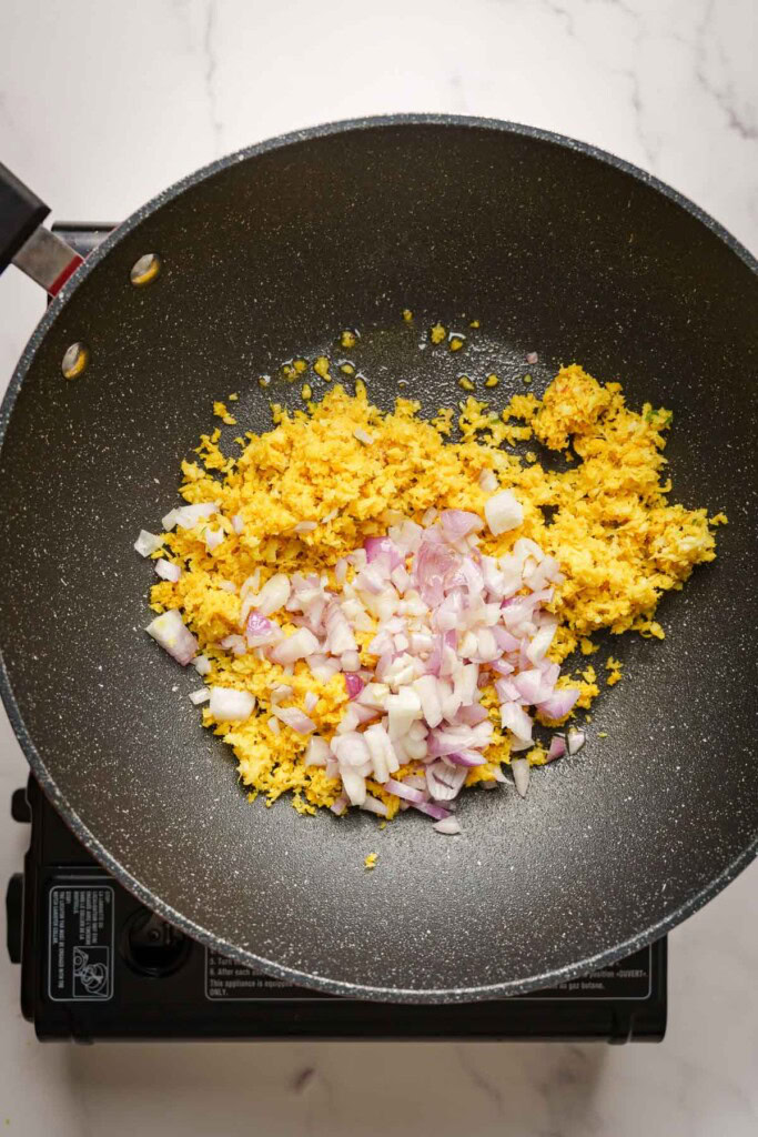 sauteing the coconut in a pan.
