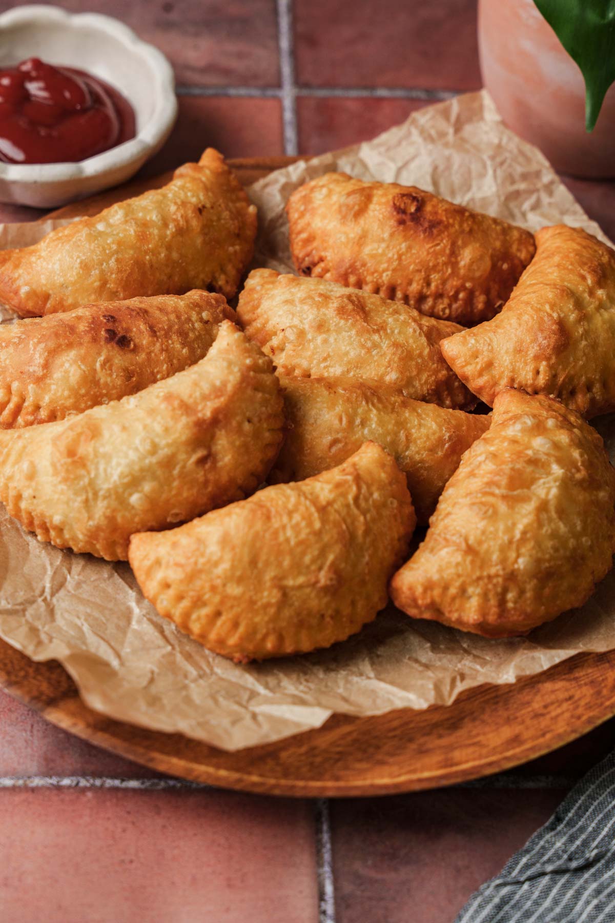sri lankan chicken patties on a plate with ketchup on the side.