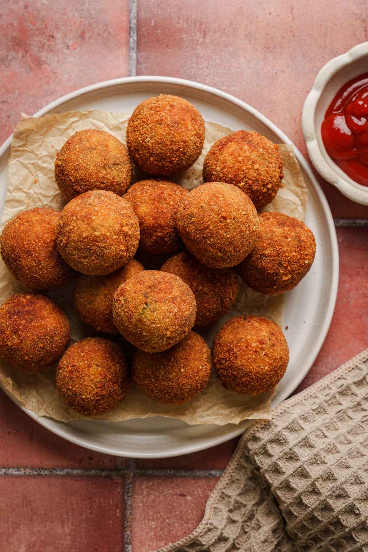 sri lankan fish cutlets on a plate with ketchup on the side.
