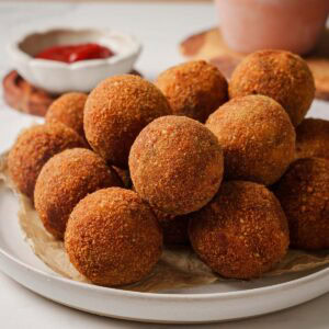 sri lankan fish cutlets on a plate with a side of ketchup.