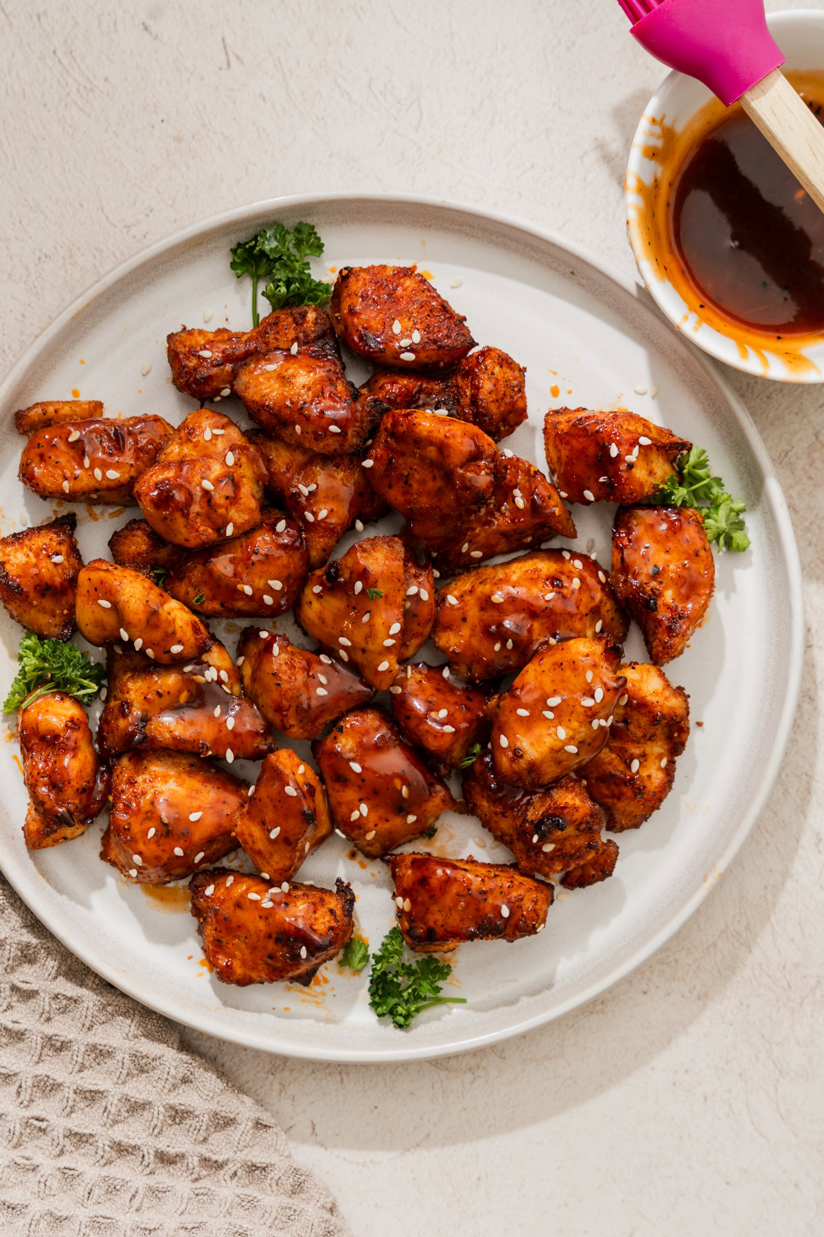 air fryer chicken bites on a plate with a side off bbq sauce.