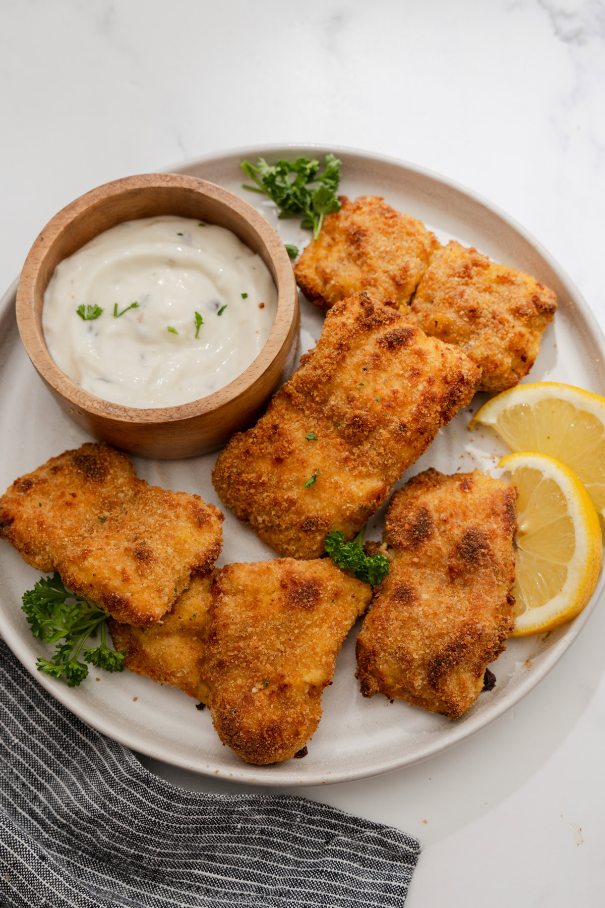 crispy fried fish fillets on a plate with tartar sauce.