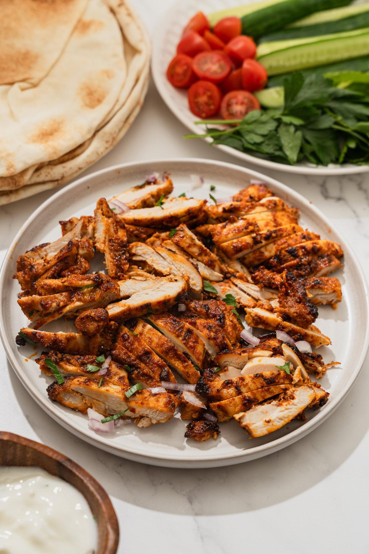 air fryer harissa chicken sliced on a plate.