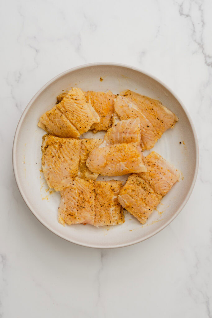 seasoned fish fillets in a bowl.